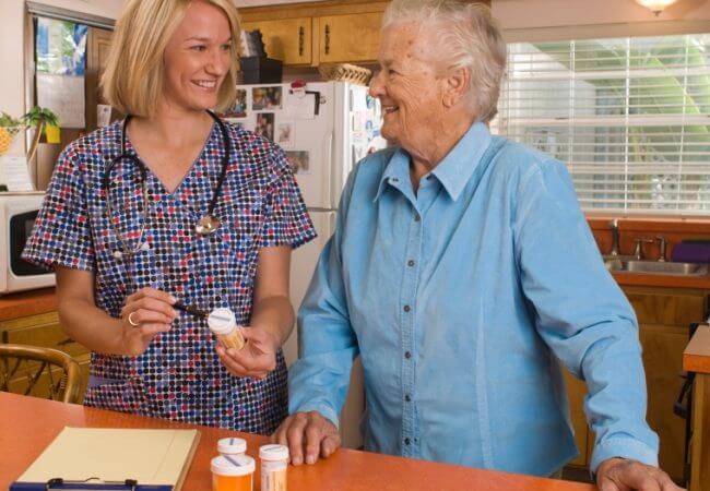 home health nurse explains medication to a senior
