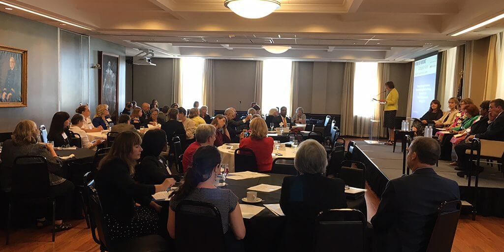 Members of the Champion Nursing Council and the Champion Nursing Coalition sit in a large meeting room. 