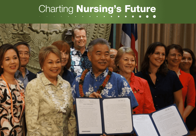 Hawaii Action Coalition co-lead Mary Boland (in navy) and Hawaii State Center for Nursing Director Laura Reichhardt (in black) joined supporters of preceptor tax-credit legislation sponsored by State Senator Rosalyn Baker (in orange) at a June 13th ceremony, where Hawaii Governor David Y. Ige (center) signed the bill into law.