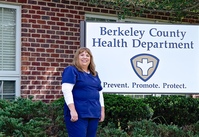 Angela Gray stands outside the Berkeley County Health department, but its sign.